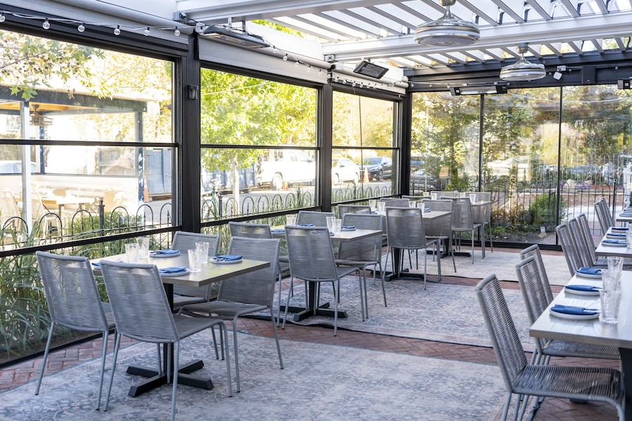 covered outdoor patio with metal dining sets and string lights