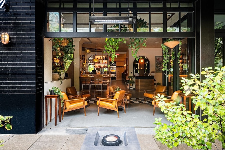 indoor/outdoor patio space with plants, chic outdoor furniture, and a fire pit at Eaton DC