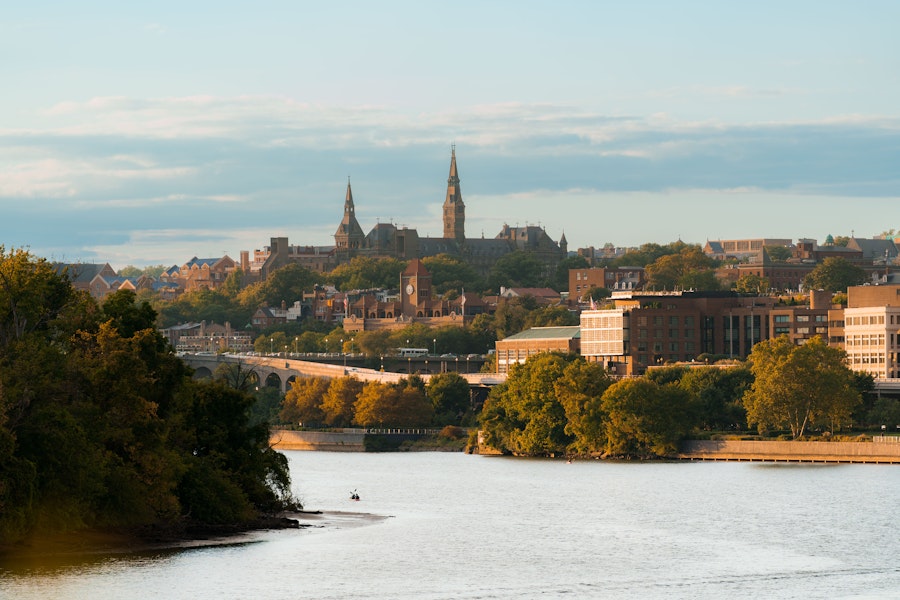 View of Georgetown with buildings and trees by the Potomac River.