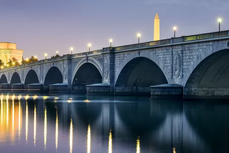 Arlington Bridge lit up at night with DC Skyline featuring Lincoln Memorial and Washington Monument 